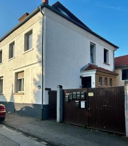 a white house with a fence in front of it at modernes Apartment mit Wlan in Lorsch