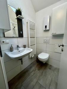 a bathroom with a white sink and a toilet at modernes Apartment mit Wlan in Lorsch