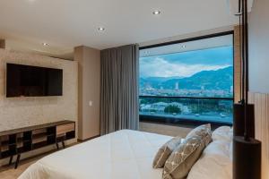 a bedroom with a large window with a view of a city at Cozy Loft in Class 48 in Sabaneta
