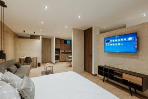 a bedroom with a bed and a tv on a wall at Cozy Loft in Class 48 in Sabaneta