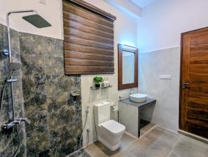 a bathroom with a toilet and a sink and a shower at Ceylan Breeze Beach Resort in Tangalle +88 photos