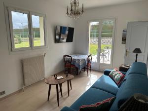 a living room with a blue couch and a table at Garden-level studio in Hautot-sur-Mer