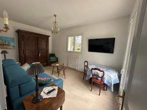 a living room with a blue couch and a table at Garden-level studio in Hautot-sur-Mer +9 photos