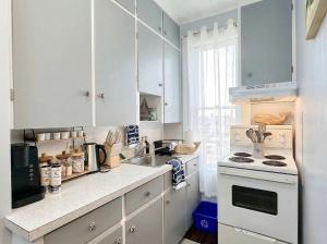 a kitchen with white cabinets and a sink and a stove at King Bed 2BR near the LaHave River and Trails in Bridgewater +20 photos