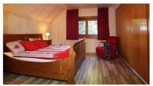 a bedroom with a bed with red pillows and a window at Lovely chalet in Alps in Bad Kleinkirchheim