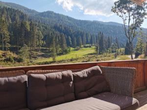 a couch on a balcony with a view of a mountain at Lovely chalet in Alps in Bad Kleinkirchheim