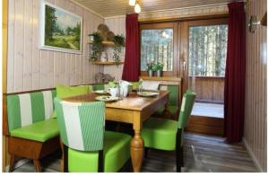 a dining room with a wooden table and green chairs at Lovely chalet in Alps in Bad Kleinkirchheim