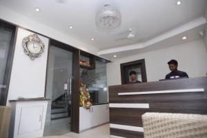two men standing at the counter of a restaurant at Hotel Center Point in Bhubaneshwar