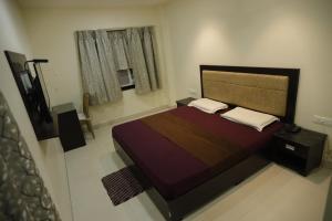 a small bedroom with a bed and a window at Hotel Center Point in Bhubaneshwar