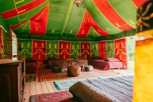 a room with a tent with red and green at Au Bonheur Nomade in Livry