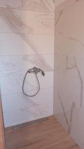 a shower with a metal shower head on a wall at BUNGALOV COZY UNA in Kulen Vakuf