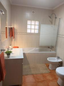 a bathroom with a tub and a toilet and a sink at Cantinho do Sol in Mosteiros +34 photos