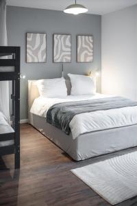 a bedroom with a large bed with three pictures on the wall at Ruhiges City-Wohnapartment - 5 min zum Markplatz in Annaberg-Buchholz