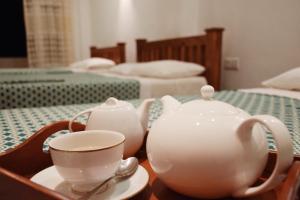 a tea set on a table with a tea pot and a cup at Queens Ark in Adams Peak