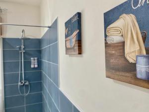 a blue tiled bathroom with a shower and a picture at A casa di Nonna Maria in Marsala +58 photos
