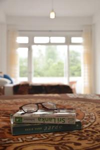 a pair of glasses sitting on top of two books at Queensark in Adams Peak