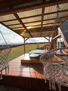 a porch with a hammock and a table and chairs at Cabana Refugio in Bălceşti