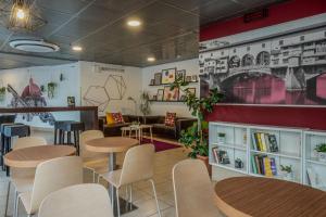 a restaurant with tables and chairs and a couch at B&B Hotel Firenze Nuovo Palazzo Di Giustizia in Florence