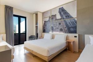 a hotel room with a bed and a painting on the wall at B&B Hotel Firenze Nuovo Palazzo Di Giustizia in Florence