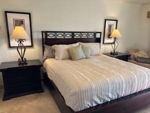 a bedroom with a large bed with two lamps on tables at Beautifully Maintained 2-Bed Condo in Las Mañanitas in San José del Cabo +9 photos