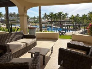 a patio with a couch and chairs and a pool at Beautifully Maintained 2-Bed Condo in Las Mañanitas in San José del Cabo