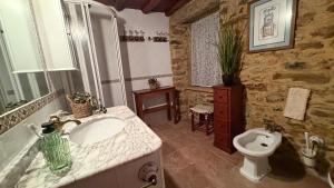 a bathroom with a sink and a toilet at Rego de Cora By Oktheway in Valcarría