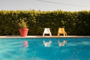 a couple of chairs sitting next to a swimming pool at Domaine de Bertranet - Chambres D'Hôtes in Tonneins