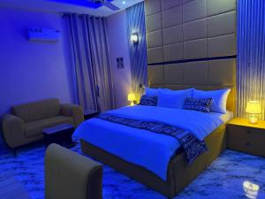 a bedroom with a large bed and a chair at Unique CityLife Hotel in Etoi