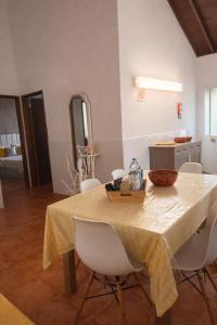 a dining room table with a yellow table cloth on it at Cantinho do Sol in Mosteiros