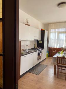 a kitchen with white cabinets and a table and a dining room at A casa di Nonna Maria in Marsala