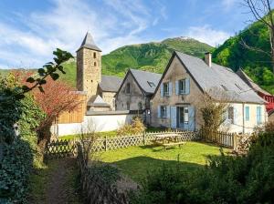 a large stone house with a church and a fence at Chez requenna in Borce