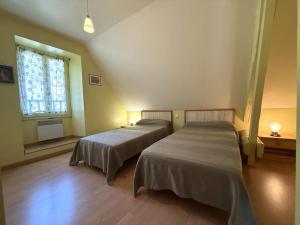 two beds in a room with a window at Chez requenna in Borce