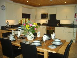 a kitchen with a wooden table with flowers on it at Melbury Chalet in West Stour