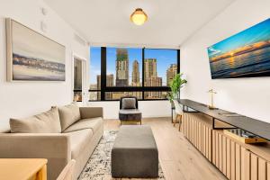 a living room with a couch and a large window at Miami Oasis 2BR Apt Pool & Beach Access for 5 in Miami