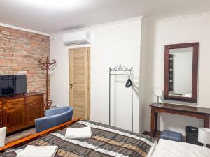 a bedroom with a bed and a mirror and a tv at Sommeliérka - ubytování & vinný sklep in Valtice