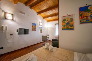 a bedroom with a bed and a tv on the wall at Case Ruggero in Cefalù