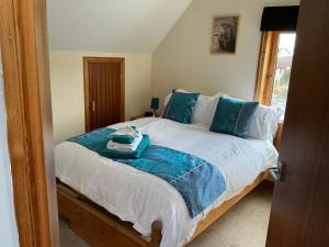 a bedroom with a large bed with blue pillows at Apartment 2, Craigmore, Upper Baila, Lerwick in Lerwick