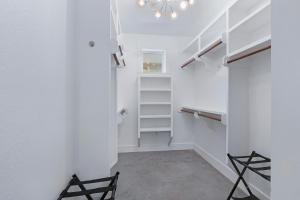 a walk in closet with white walls and a chandelier at Gatlin Getaway in Dripping Springs