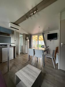 a kitchen and dining room with a table and chairs at Chez Maxime - E33 - Clim TV Lave-vaisselle - Proche Europa Park et Rulantica in Boofzheim