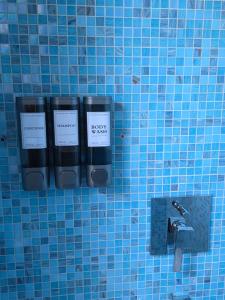 a blue tiled wall with two bottles of soap at Home Little Star in Gorizia