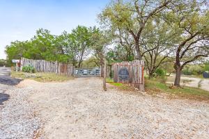 a fence with a sign on it next to a road at Good Day Treehouse in Wimberley