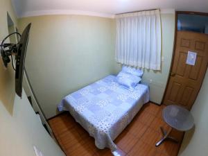 a small bedroom with a bed and a door at Hostal Aurora a 3 cuadras de la Plaza de Armas in Cajamarca