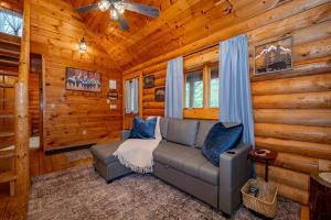 a living room with a couch in a log cabin at Johnsons Creek Cabin by Railey Vacations in Oakland
