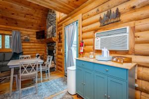 a kitchen and dining room with a table in a log cabin at Johnsons Creek Cabin by Railey Vacations in Oakland