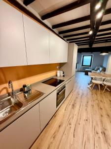 a kitchen with white cabinets and a wooden floor at CASA LALLINO - Tuscan ToBe srl in Santa Fiora