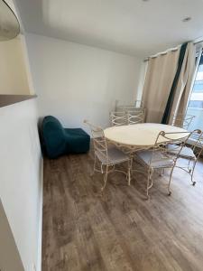 a dining room with a table and chairs in a room at Hyper centre parking privé in La Roche-sur-Yon +3 photos