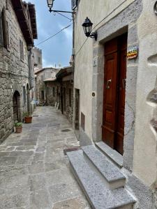 an alley with a wooden door in an old building at CASA LALLINO - Tuscan ToBe srl in Santa Fiora
