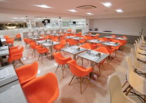 a dining room with tables and orange chairs at Nord Luxxor Citymix in Campina Grande