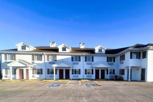 a large white building with a parking lot at Osage Village Inn Near Lake Ozarks US 54 in Osage Beach