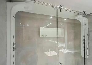 a glass shower door with a mirror in a room at Nord Luxxor Citymix in Campina Grande +58 photos
